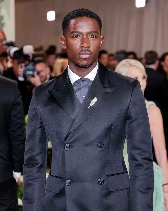 Damson Idris in a black double-breasted suit at a formal event, exemplifying the most handsome man in the world 2025.
