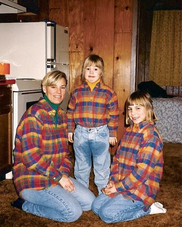 Foto familiar con error divertido, tres personas con camisas a cuadros iguales y pantalones vaqueros en interior de casa.