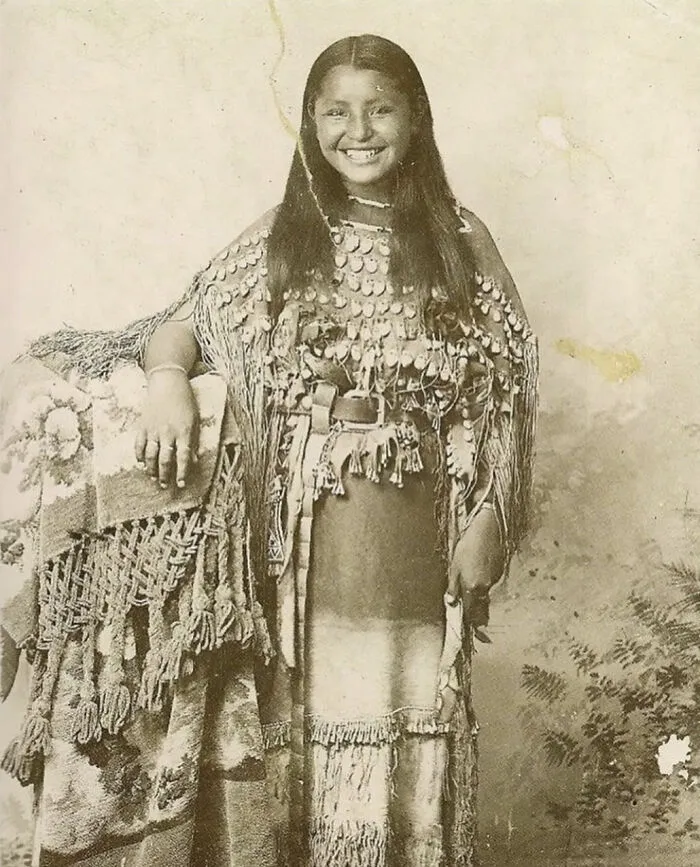 Una niña kiowa llamada O-O-Be viste un vestido de tres pieles decorado con dientes de alce, Oklahoma, 1894
