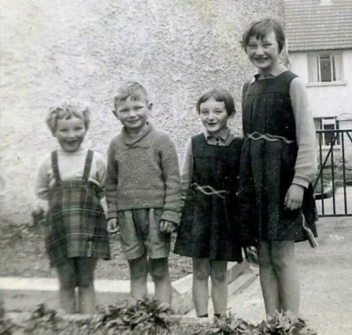 Un joven Liam Neeson fotografiado con sus hermanas, Elizabeth, Bernadette y Rosaleen, en 1960 frente a su casa familiar en Ballymena, Condado de Antrim, Irlanda del Norte.