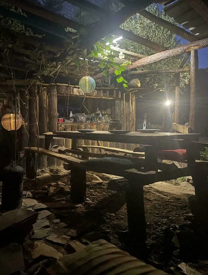 Cozy off-grid cabin interior at night with rustic wooden furniture, soft lighting, and natural elements for peaceful disconnect.