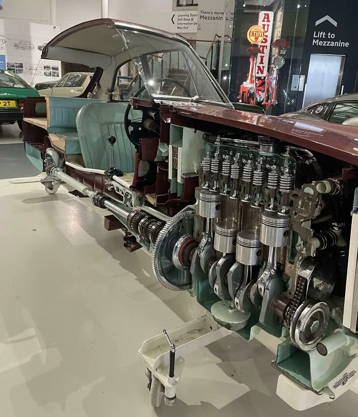 Cutaway view of a classic car showing intricate internal engine components and mechanical systems inside.