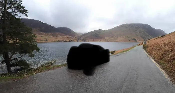 Scenic lakeside road with mountains under cloudy sky, illustrating a popular where was this taken internet post.