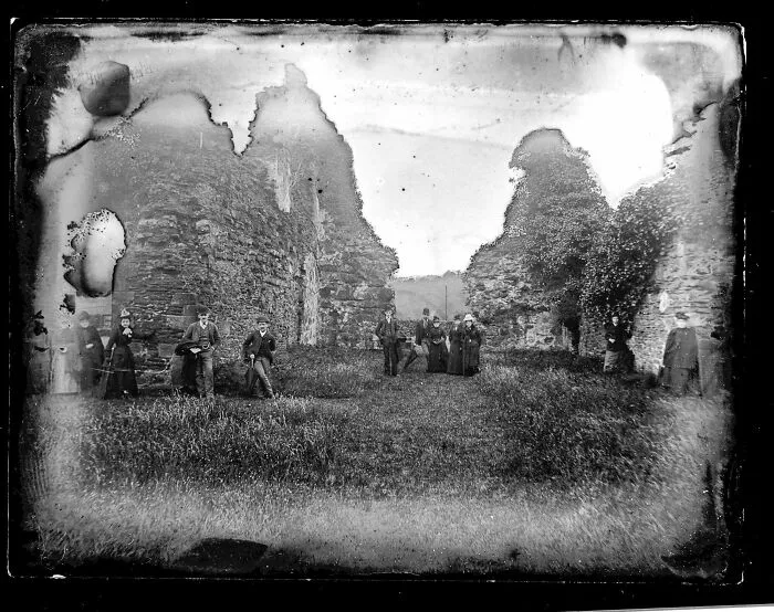 Group of people standing amid ancient stone ruins in a black and white photo for where was this taken posts