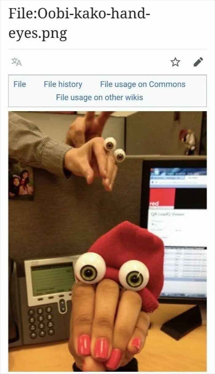 Hand puppets with fake eyes on fingers creating funny characters in an office setting from cracked Wikipedia pages online.