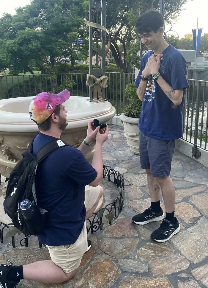Person proposing on one knee turning a big dream into reality while the other looks emotional and inspired outdoors.
