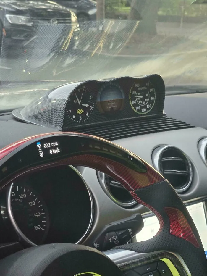 Car interior with a modified dashboard display showing cockpit instruments, an example of stupidity on wheels customization.