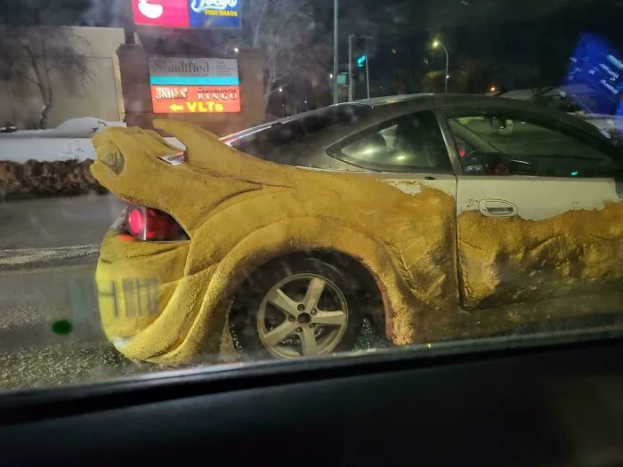 Car modification fail with a large, bulky sculpture attached, illustrating stupidity on wheels and failed cool car designs.