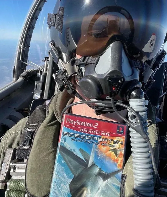 Pilot wearing a flight helmet holding PlayStation 2 Ace Combat 04 game, showcasing people turning dreams into reality inspiration.