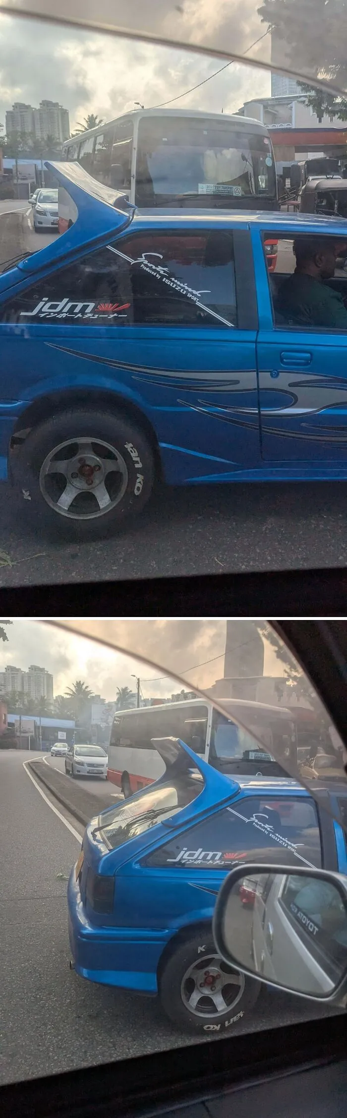 Blue car with oversized rear spoiler and Japanese-style decals, an example of stupidity on wheels car modifications on the road.