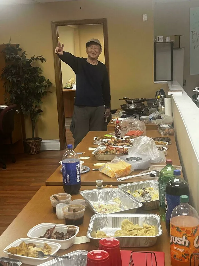 Man giving peace sign next to a table full of food and drinks, showcasing wholesome internet moments.