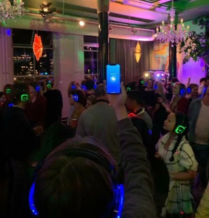 People wearing colorful headphones dancing at a lively party showing men never grow up in fun moments