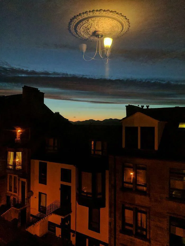 Night cityscape with building lights and a glowing ceiling light reflected, a confusing photo that puzzles the brain.