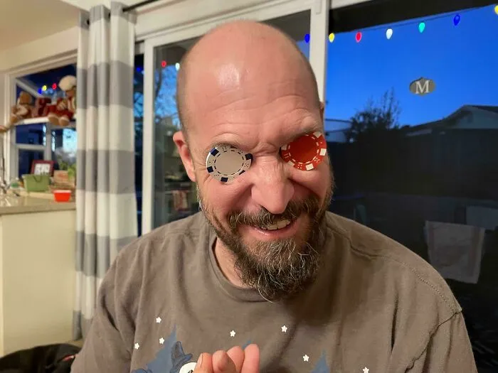 Man playing with poker chips covering his eyes, showing playful and wholesome moments that prove men never grow up.