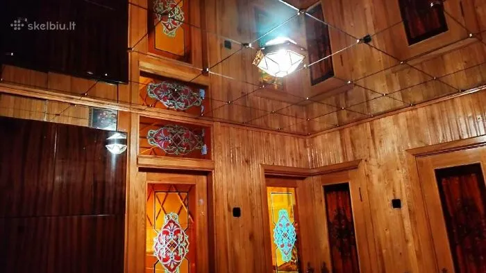 Interior de vivienda con paredes y puertas de madera decoradas, mostrando listados inmobiliarios entretenidos y únicos.