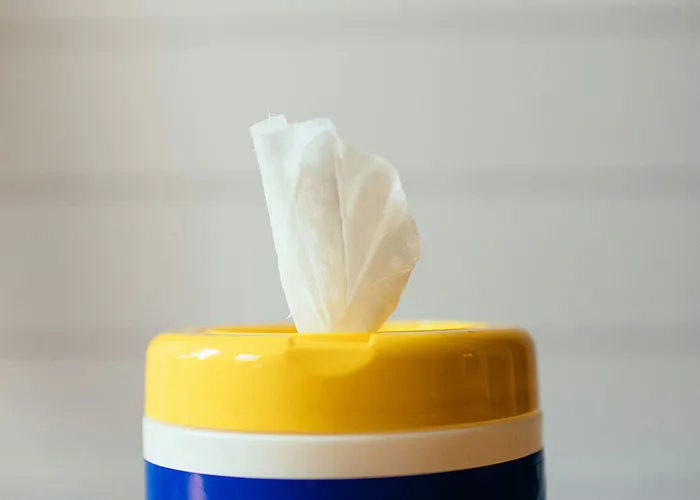 Container of cleaning wipes with a tissue pulled out, illustrating genius cleaning hacks inspired by laziness.