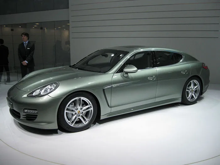Luxury sports car displayed indoors with security personnel nearby, illustrating some folks don’t deserve nice things.