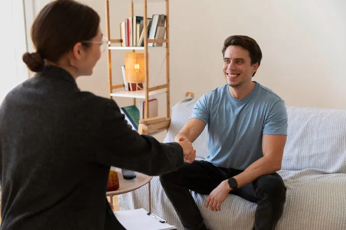 Two people shaking hands during a conversation about people who disappeared to start new lives and reveal their experiences.