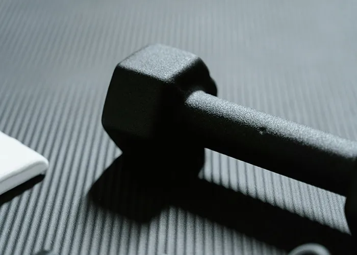 Black dumbbell lying on a textured mat representing one of the absolute horrible gifts people have actually received.