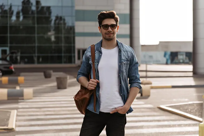 Young man wearing sunglasses and a denim shirt standing outdoors, symbolizing people who disappeared into thin air.