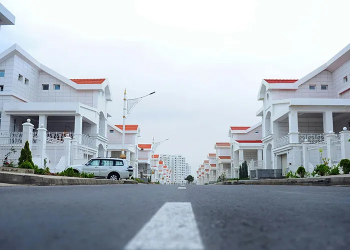 Residential street with white houses and parked cars, representing one of the worst cities worldwide to avoid visiting.