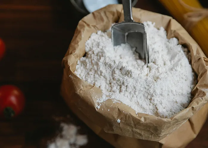 Brown paper bag filled with flour and a metal scoop, illustrating a horrible gift received by 91 people.