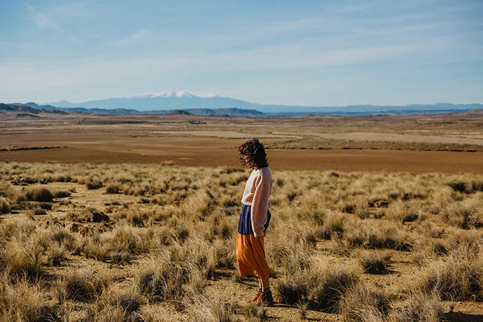 Solo female traveler standing alone in a vast, remote landscape reflecting on places solo female travelers do not recommend.