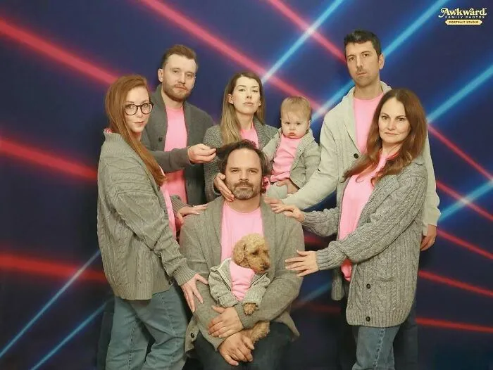 Foto familiar con fallas cómicas, siete personas y un perro vestidos igual, luces de fondo rojo y azul en estilo retro.