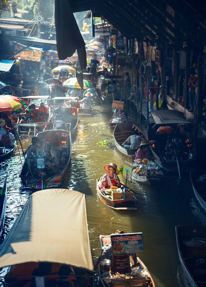 Busy floating market with vendors on boats selling goods in a vibrant street photography scene around the world.