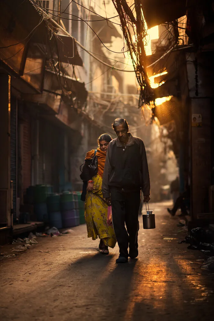 Couple walking in a narrow alleyway at sunset, captured in warm light with street photography around the world.