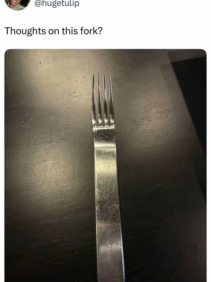 Fork with an unusually wide and flat handle on a dark table, part of entertaining posts and memes to fight boredom.