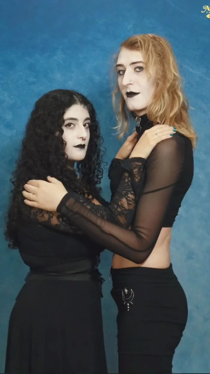 Dos personas vestidas de negro con maquillaje gótico posan juntos para una foto familiar con fallos inolvidables.