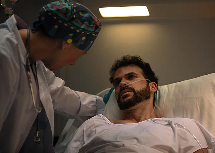 Doctor comforting a male patient in hospital bed, highlighting wild family dramas that make relatives seem normal.