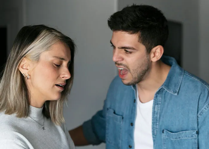Young man angrily arguing with a young woman indoors, illustrating intense family drama and conflict scenes.