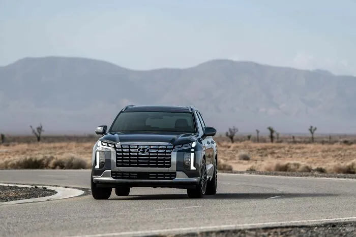 Black Hyundai SUV driving on a desert road with mountains in the background, illustrating laws and loopholes concept.