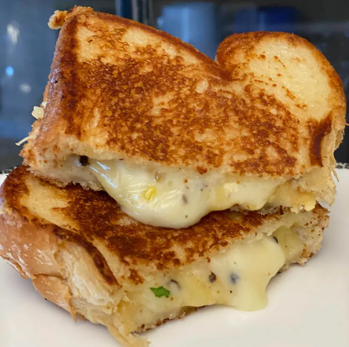 Close-up of a golden grilled cheese sandwich with melted cheese, demonstrating cooking skills and kitchen tips.