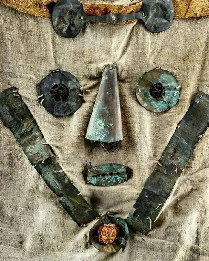 Very old metal objects arranged on fabric, showing ancient craftsmanship and artifacts related to our ancestors.