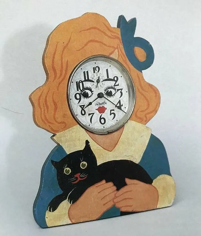 Vintage clock with a girl and black cat design, a very old object showcasing stories from our ancestors.