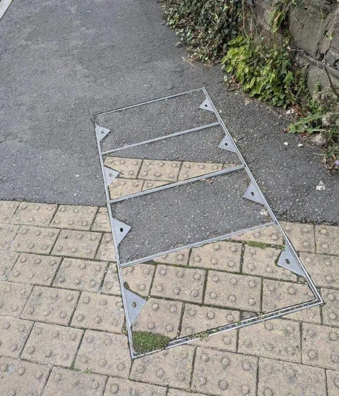 Marco metálico mal colocado en acera con diseño irregular que muestra fallo de arquitectos y diseñadores en planificación urbana.