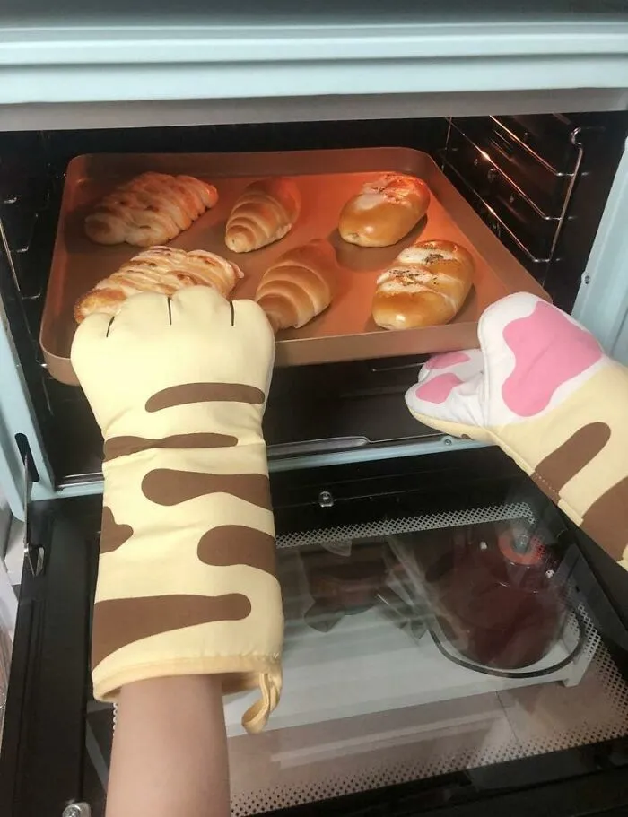 Pulling A 400-Degree Pan From The Oven Can Now Be Done With Paws That Would Clearly Rather Be Napping In A Sunbeam Thanks To These <a Style="Display:inline;" Href="Https://Www.amazon.com/Dp/B08cl5w75q?ascsubtag=7978792%2c5%2c49%2cd%2c0%2c0%2cbf-G-Cp%2c1396%3a1%3b1338%3a1%2c73408737%2c0%2c0%2c0&btn_ref=srctok-F3b816ee9f8d2dd1&th=1&linkcode=ll1&tag=bpcrocodile-20&linkid=e25317c50715499ae67f806529b0cfb8&language=en_us&ref_=as_li_ss_tl" Target="_blank">   <span Style="Font: Inherit; Color: #d74b1f;"> Cat Paw Oven Mitts </Span>