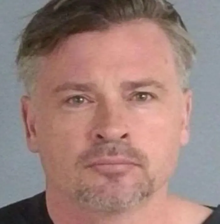 Mugshot of a man with short hair and facial hair, part of infamous celebrity mugshots collection.