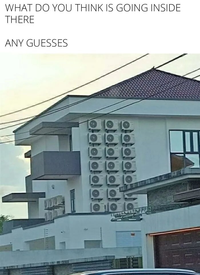 Apartment building exterior with numerous air conditioning units stacked, creating a funny and surprising visual effect.