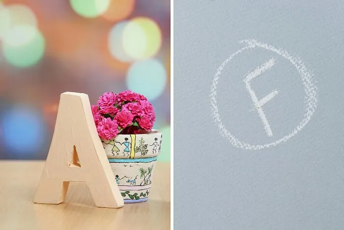Wooden letter A and pink flowers in a pot next to a chalk-drawn F grade on a gray background for public speaking dilemmas.