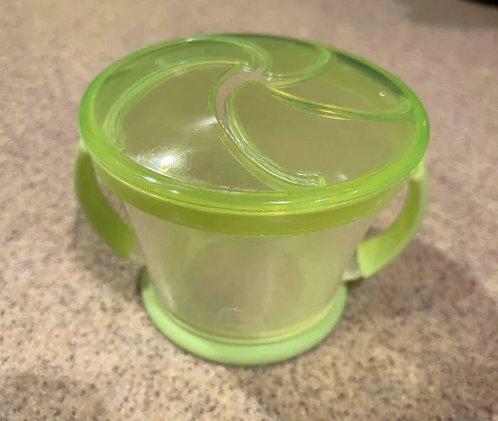 Green snack container with handles on a countertop, illustrating a wholesome funny and goofy dad moment.
