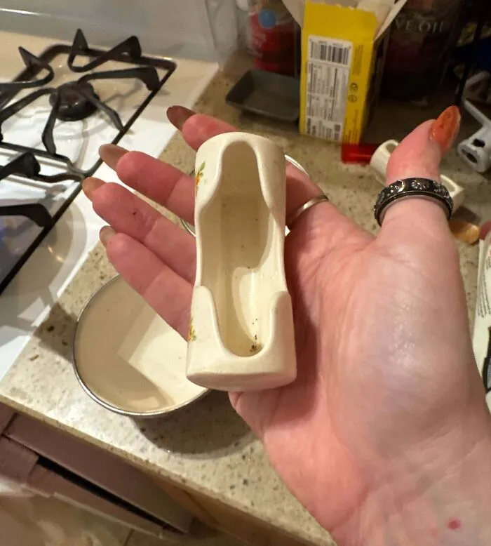 Hand holding a bizarre ceramic item resembling a miniature shoe, one of the most bizarre things people received as Christmas gifts.