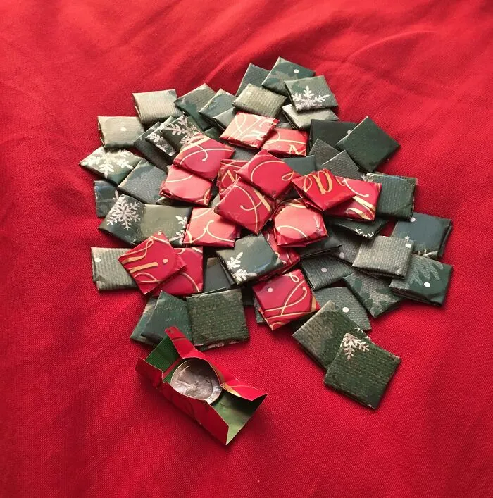 Small wrapped squares of weird Christmas gifts on a red cloth, featuring bizarre items received as holiday presents.
