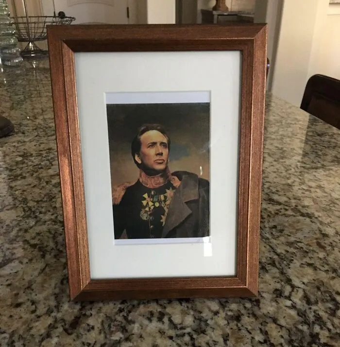 Framed bizarre Christmas gift photo of a man in historical military uniform on a kitchen countertop.