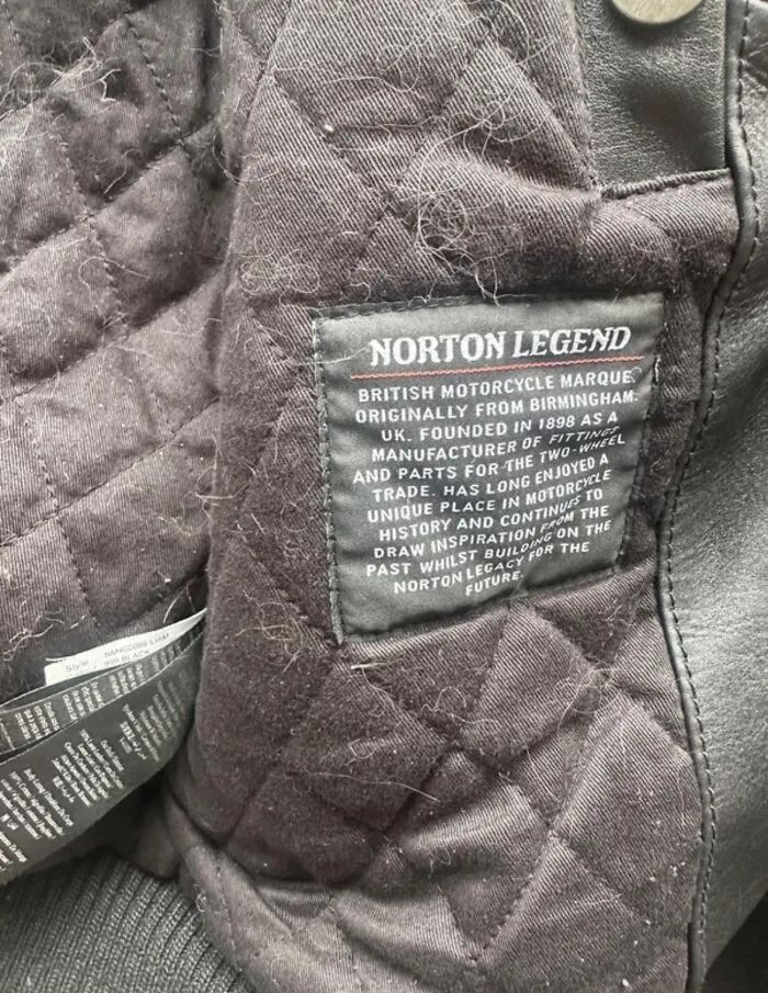Black quilted fabric with a stitched label describing the Norton Legend motorcycle brand in a second take Vinted post.