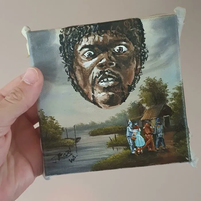 Hand holding a personalized thrifted painting with a funny unexpected giant head and small figures near a river.