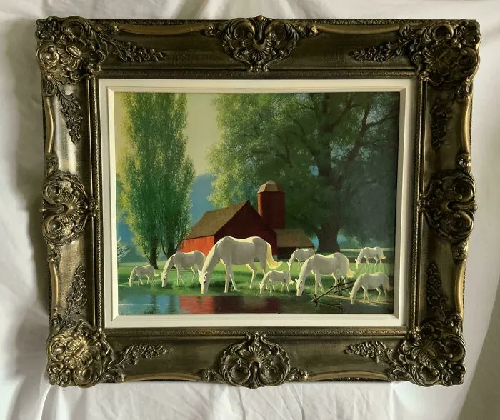 Thrifted painting of white horses grazing near a red barn, personalized with an unexpected humorous addition in an ornate frame.